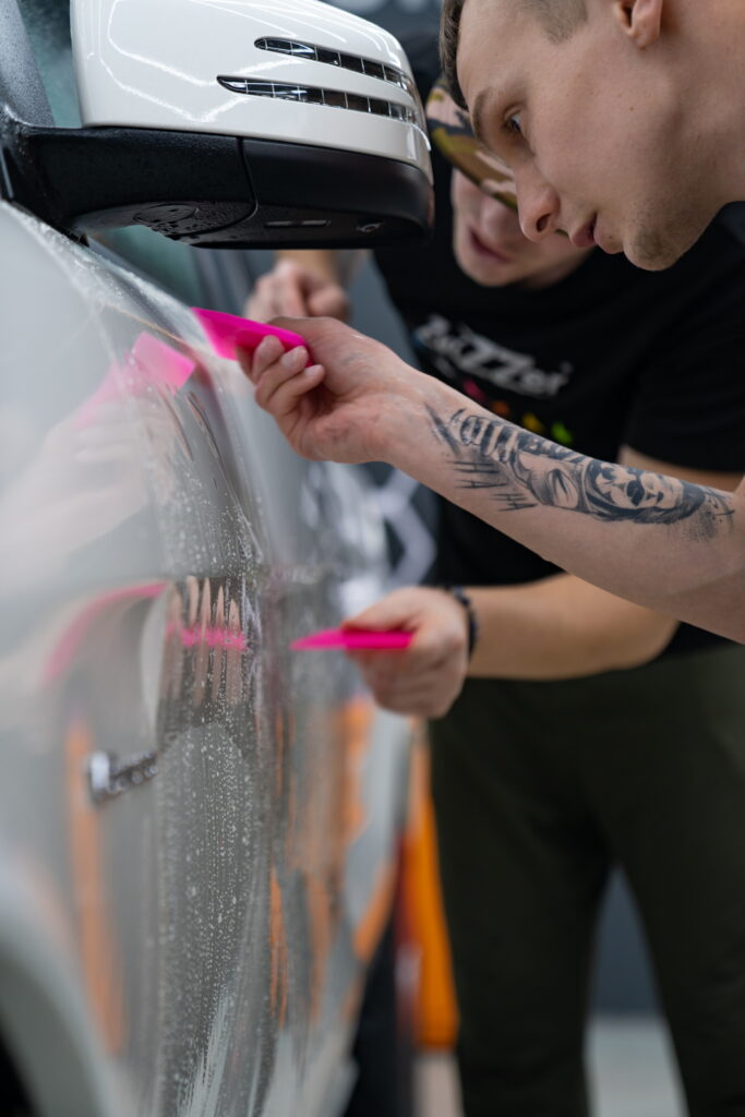 Detailer nanáša keramickú ochranu na kapotu vozidla v TN Garáž Trenčín